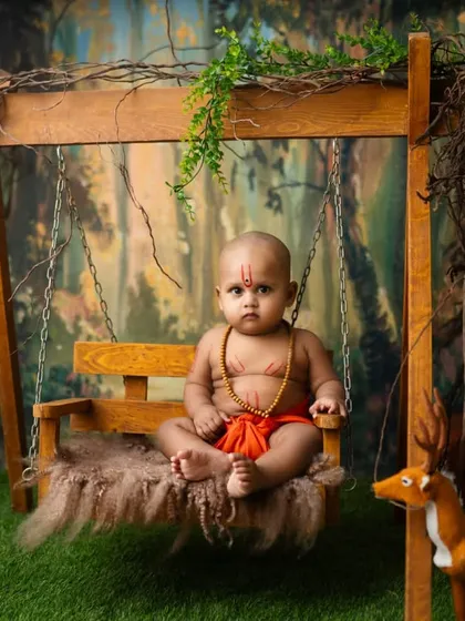 A baby dressed as a young Swami Samarth devotee, sitting peacefully on a swing in a forest setting. These spiritual themes create a sense of calm and reverence.