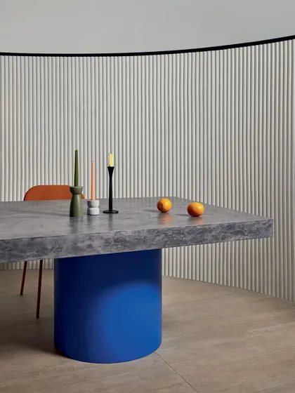 A 3D design that turns walls into soft, sculptural works of art. This dining area features a curved wall with a white, vertically ribbed wallcovering, adding architectural interest and a modern touch.