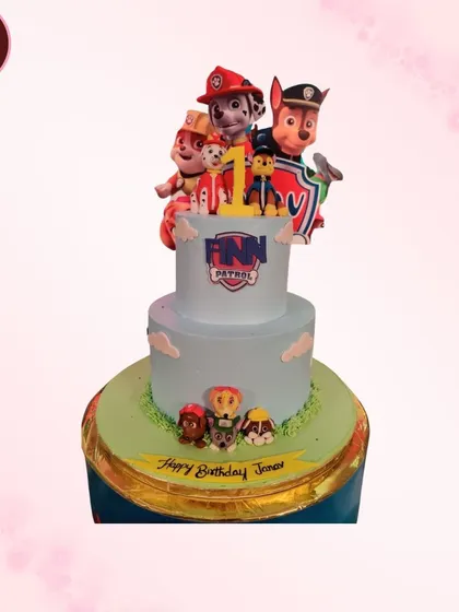 A two-tiered Paw Patrol cake for a first birthday. The design includes the iconic lookout tower and several members of the puppy rescue team.