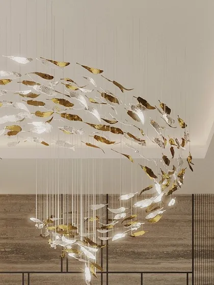 A detailed shot of the magnificent fish-inspired chandelier, which serves as the primary art piece in this grand living space. The interplay of gold and silver elements catches the light beautifully.