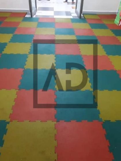 Interlocking foam tiles in a checkerboard pattern for an indoor play area. These tiles are soft, easy to install, and can be arranged in many colorful patterns.