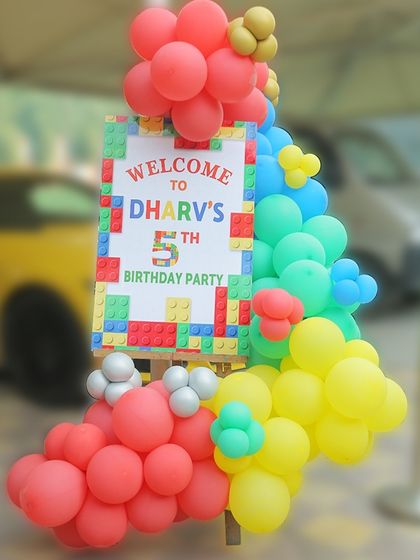 The welcome sign for Dharv's LEGO party, surrounded by a colorful balloon arrangement that sets a fun and creative tone.