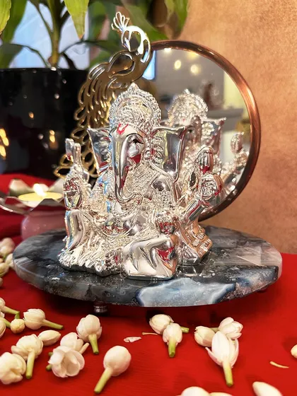 The combination of polished silver, warm gold, and cool marble makes this Ganesha idol a luxurious statement piece. It is perfect for adding a touch of modern divinity to a console table or entryway.