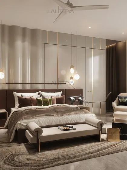 A serene bedroom oasis designed with warm neutral tones, sleek pendant lighting, and a dramatic, undulating feature wall. The mix of soft furnishings and metallic accents creates a refined yet cozy atmosphere.