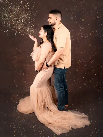 Let's celebrate your journey together. This couple's maternity portrait captures the shared excitement and love, with a touch of magic from the blowing glitter. It’s a fun, dynamic shot that freezes a moment of pure joy.