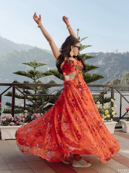 A vibrant shot of the bride, Ankurita, dancing with abandon against the backdrop of the Mussoorie hills.