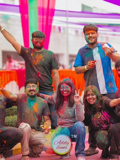 A group of colleagues posing for a photo at a corporate Holi event. Their happy expressions and colorful faces are a testament to a successful and enjoyable team-building celebration.