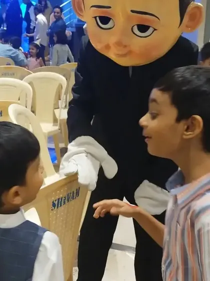 Mascot appearances make any party unforgettable. Here, the Boss Baby character is interacting with two young guests, creating a special moment for the birthday celebration.