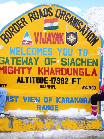 We made it to the top. Our group stands proudly at the iconic Khardungla Pass sign, the gateway to Siachen, at a breathtaking altitude of 17,982 feet. This is a key milestone in our high-altitude fitness trip.