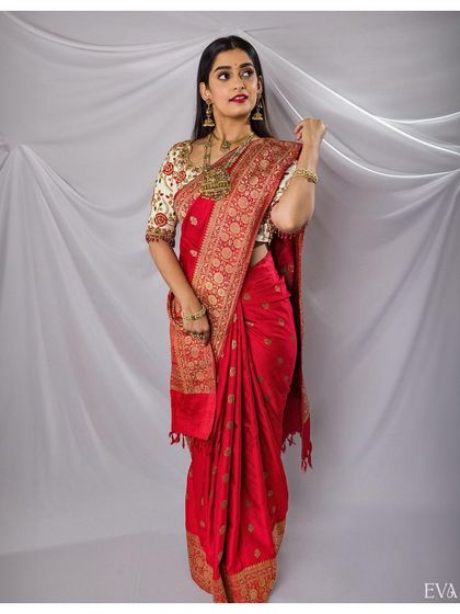 The bride looks radiant in her red silk saree, a perfect example of a classic South Indian bridal portrait.