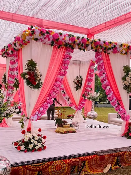 A beautiful pink and white themed mandap. The pillars are wrapped in flowers, and the draped fabric creates a soft, romantic look.