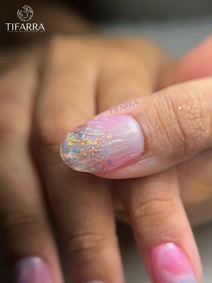 A detailed shot of the glittery tip on the cotton-candy pink nails.