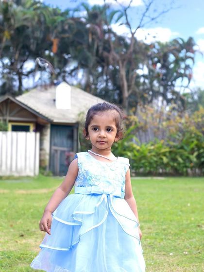 A close-up portrait of a little girl during an outdoor family shoot. The natural background and soft light create a beautiful, classic look.