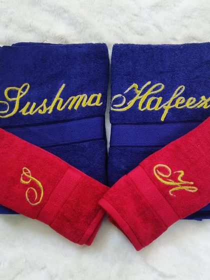 I love this bold color combination of royal blue and vibrant red towels. Each towel is customized with embroidered names and initials, making it a unique and personal gift for any couple.