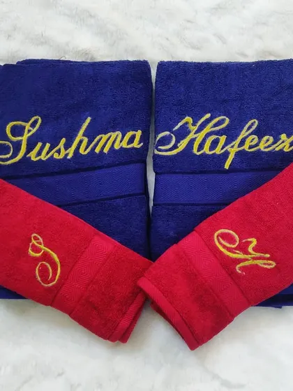 I love this bold color combination of royal blue and vibrant red towels. Each towel is customized with embroidered names and initials, making it a unique and personal gift for any couple.