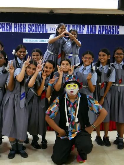 A group photo of the girls from Stephen's High School with the 'Silent Storyteller'. Their smiles and playful poses show how much they enjoyed the unique and inclusive performance.