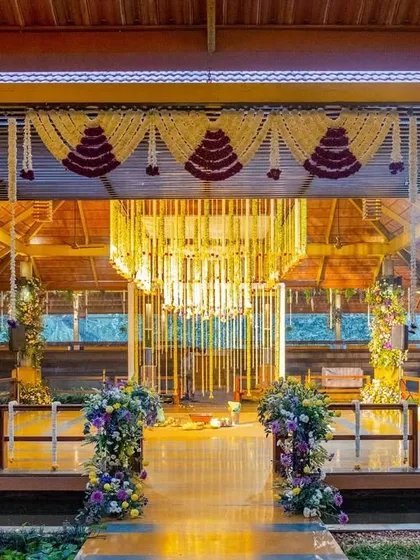 A beautiful view of the hanging floral mandap at the 'Sunrise Soirée', with purple and yellow flowers creating a vibrant contrast.