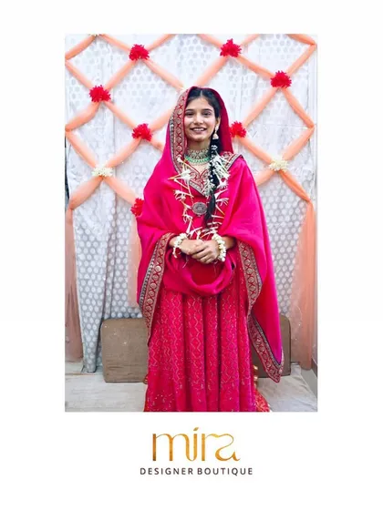 A lovely bride-to-be wearing a custom rani pink embroidered georgette Anarkali for her Mehndi ceremony. The rich color and organza dupatta create a look of effortless beauty.
