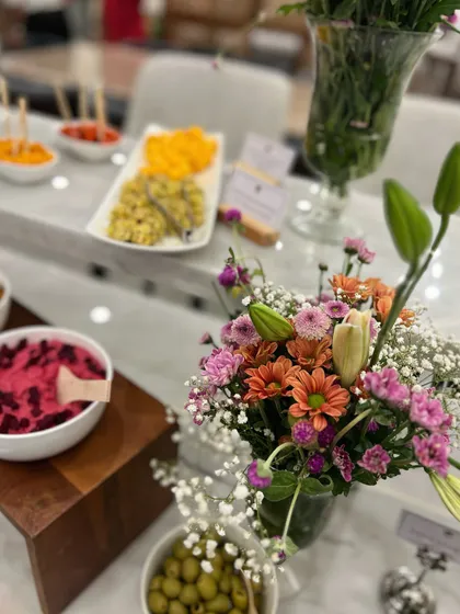A beautiful table display we created for a store opening. The setup features our fresh dips, olives, and floral arrangements, creating an inviting atmosphere for guests.