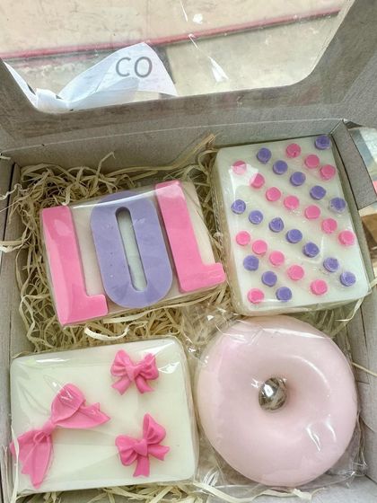 A complete LOL Doll-themed gift box. It features a variety of cute soaps, including a donut soap, a bow soap, a polka dot soap, and the LOL logo soap.