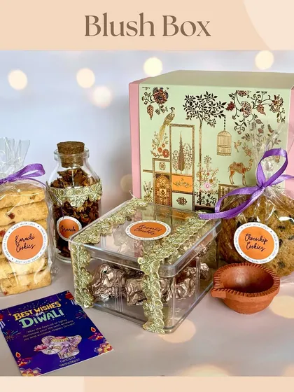 The 'Blush Box' Diwali hamper, featuring an elegant box filled with assorted chocolates, granola, cookies, and a diya. A beautiful and delicious gift for your loved ones.