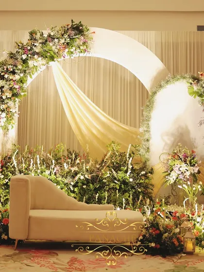 The main stage for the Roka, featuring a double-arch backdrop, soft draping, and a profusion of flowers in shades of peach, purple, and ivory.