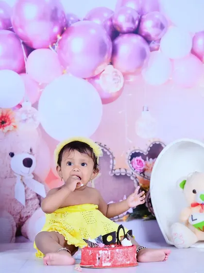 A full view of the first birthday cake smash setup with pink balloons and teddy bears.