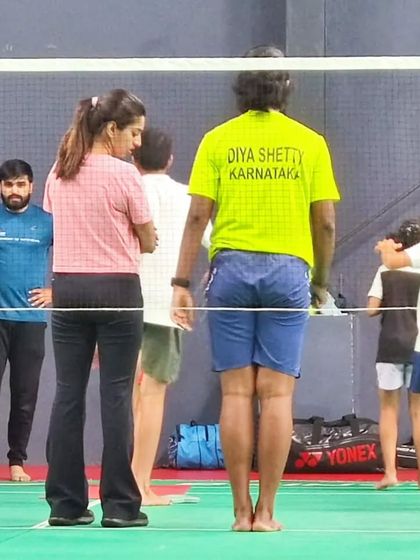 Discussing technique and form with players and coaches on the court. A collaborative approach ensures that fitness training directly supports their sports-specific needs.