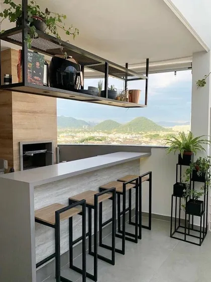 A balcony can even have a stylish bar. I helped design this space with custom metal plant stands that fit the modern, industrial aesthetic, adding a touch of green to the beautiful view.