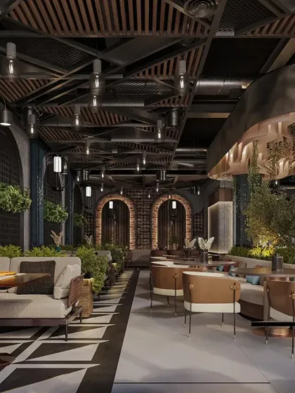 This long shot of the restaurant shows the different seating zones, from comfortable sofas to dining tables. The design uses planters and varied flooring to define spaces within the open-plan layout.