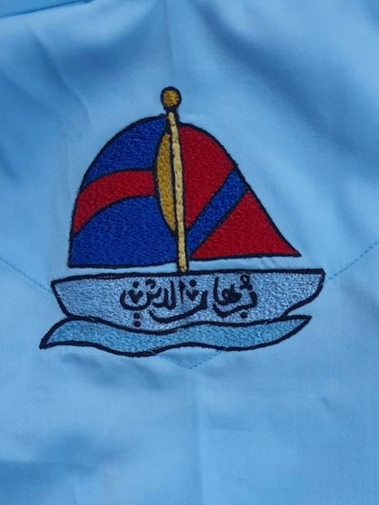 This boat embroidery, with the child's name in Arabic script, was part of a custom-themed saya kurta for a first birthday celebration.