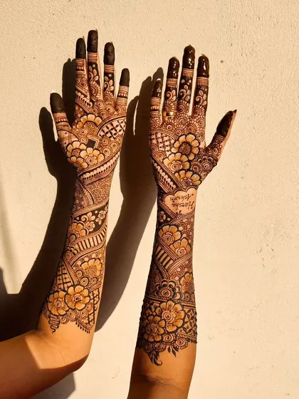 The sunlight brings out the warm, rich tones of this mature bridal henna stain. The color is consistent from the fingertips all the way up the arms.