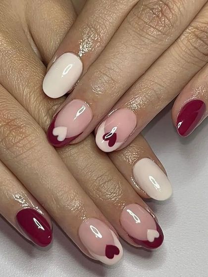 A lovely Valentine's theme with a mix of solid red, white, and accent nails featuring a "negative space" heart design.