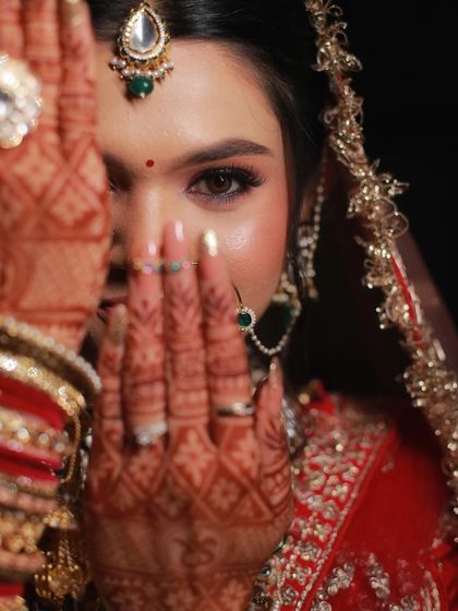 Sneha's bridal portraits are simply breathtaking. The dramatic lighting highlights the soft glam makeup, focusing on her expressive eyes.
