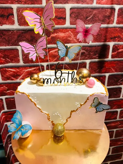 A beautiful butterfly-themed cake celebrating a 6-month milestone.