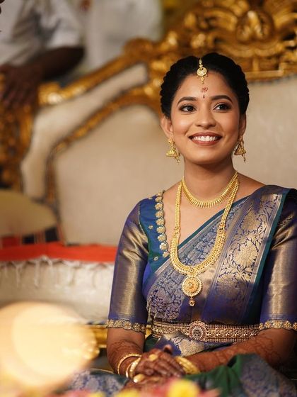 A beautiful, smiling portrait of the bride during her ceremony. The makeup enhances her natural beauty and looks flawless even in the bright event lighting.