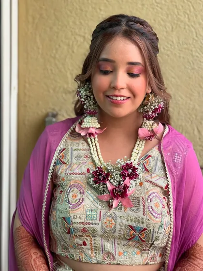 A close-up of the bride's makeup, her pink eyeshadow perfectly matching the flowers in her jewellery.