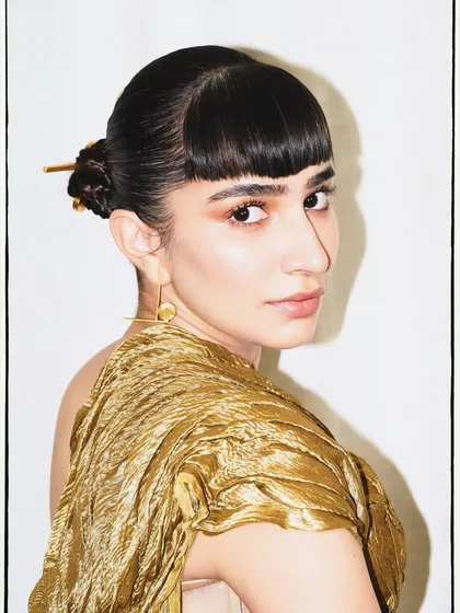 A beauty shot capturing the essence of the look, with a focus on the unique texture of the gold top and the sharp, modern hairstyle.