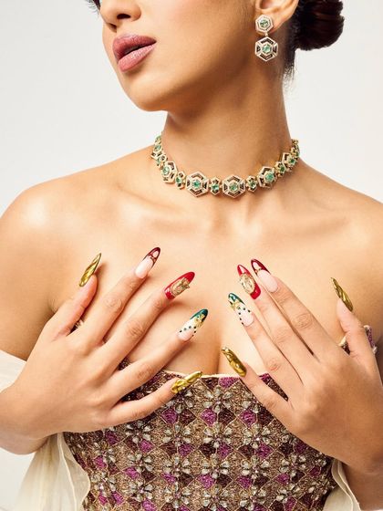 A close-up of the jewel-toned nails I created to match this gorgeous embellished top. The gold chrome and deep red and green art add a touch of luxury.