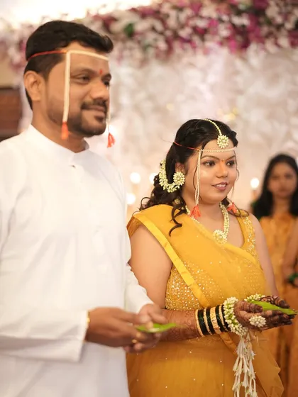 The bride and groom together during the Haldi rituals. Her look is traditional, with floral jewellery and a simple, elegant hairstyle.