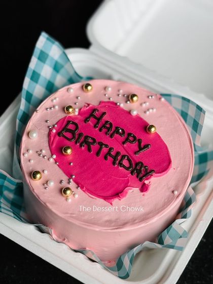 A modern pink birthday bento cake with a bold splash of colour and gold details.