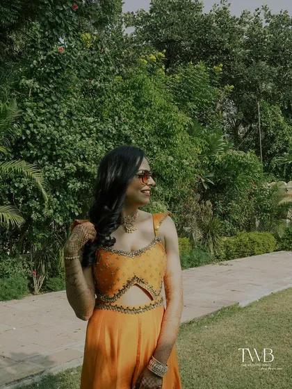 A candid shot of the bride enjoying the sun during her outdoor haldi event. Her relaxed posture and happy expression perfectly capture the chill vibe of the afternoon.