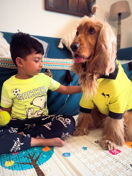 A quiet moment between Posto and his human cousin, sharing a toy and a special bond.