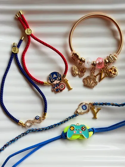 A glimpse into our hand-curated Rakhi collection. We design unique rakhis with personalised initials and fun charms like superheroes, evil eyes, and game controllers, celebrating the special bond between siblings.