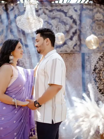 A tender moment of connection. The unique, carpeted backdrop and warm lighting create an intimate and artistic atmosphere for this pre-wedding shot.