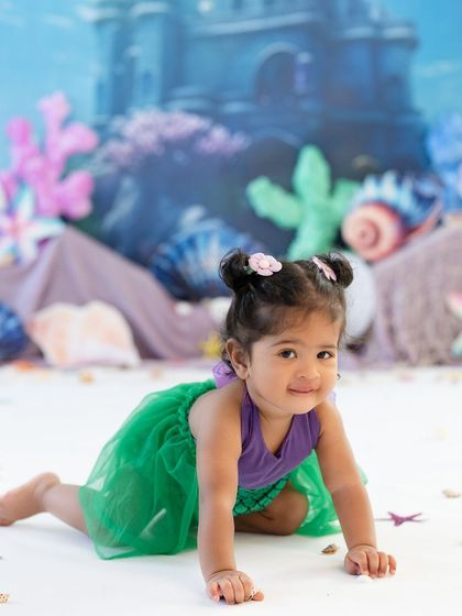 Our little mermaid is crawling toward her next adventure. The underwater backdrop and her adorable costume make for a magical action shot.