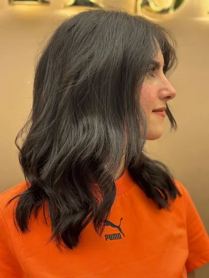 A side view of a client's new haircut, showing the soft layers and gentle waves that create a beautiful, flowing style.