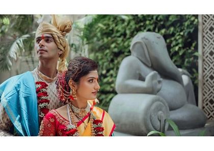 A regal portrait of the couple. The composition, with the Ganesha statue in the background, adds a traditional and artistic element to this wedding photograph.