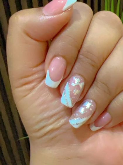 A classic French manicure with a twist, featuring light blue tips and silver foil accents on a square-shaped nail.