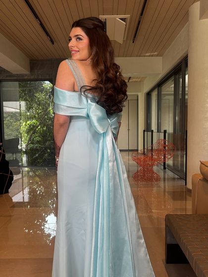 A full-length shot showing how the romantic hairstyle and the large bow on the back of the dress work together to create a stunning, cohesive look.